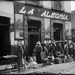 Escena callejera frente a la fonda-pulquería La Alegría alrededor de 1904. Este establecimiento se encontraba en la esquina que forman las calles de Roldán y Manzanares, en el barrio de La Merced.